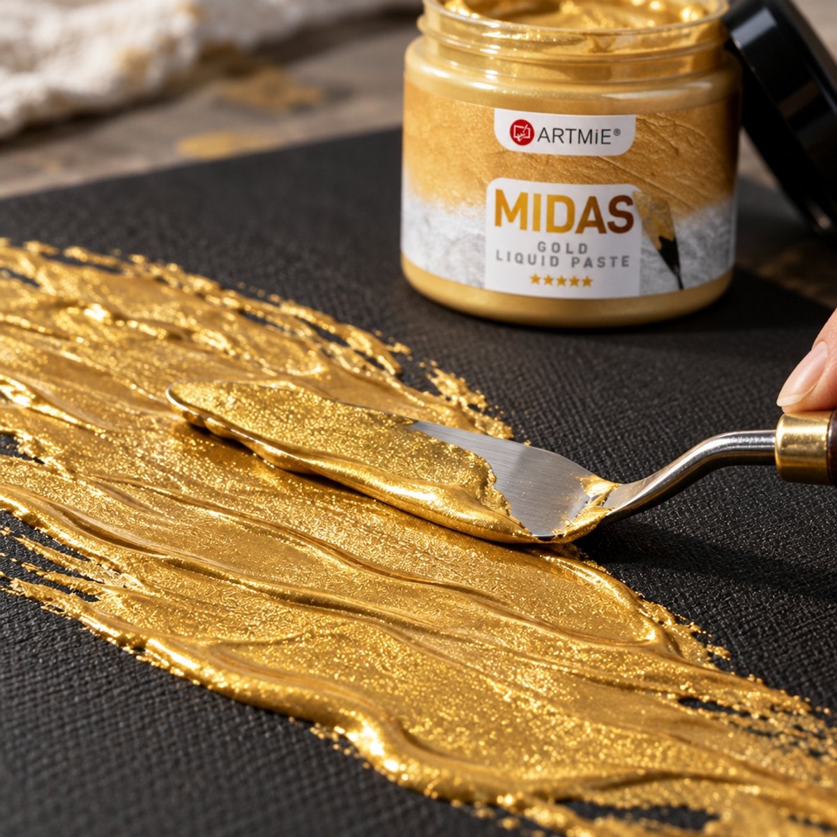 Auftragen der goldenen Metallic-Paste ARTMIE MIDAS mit der Spachtel auf schwarze Leinwand — Makro