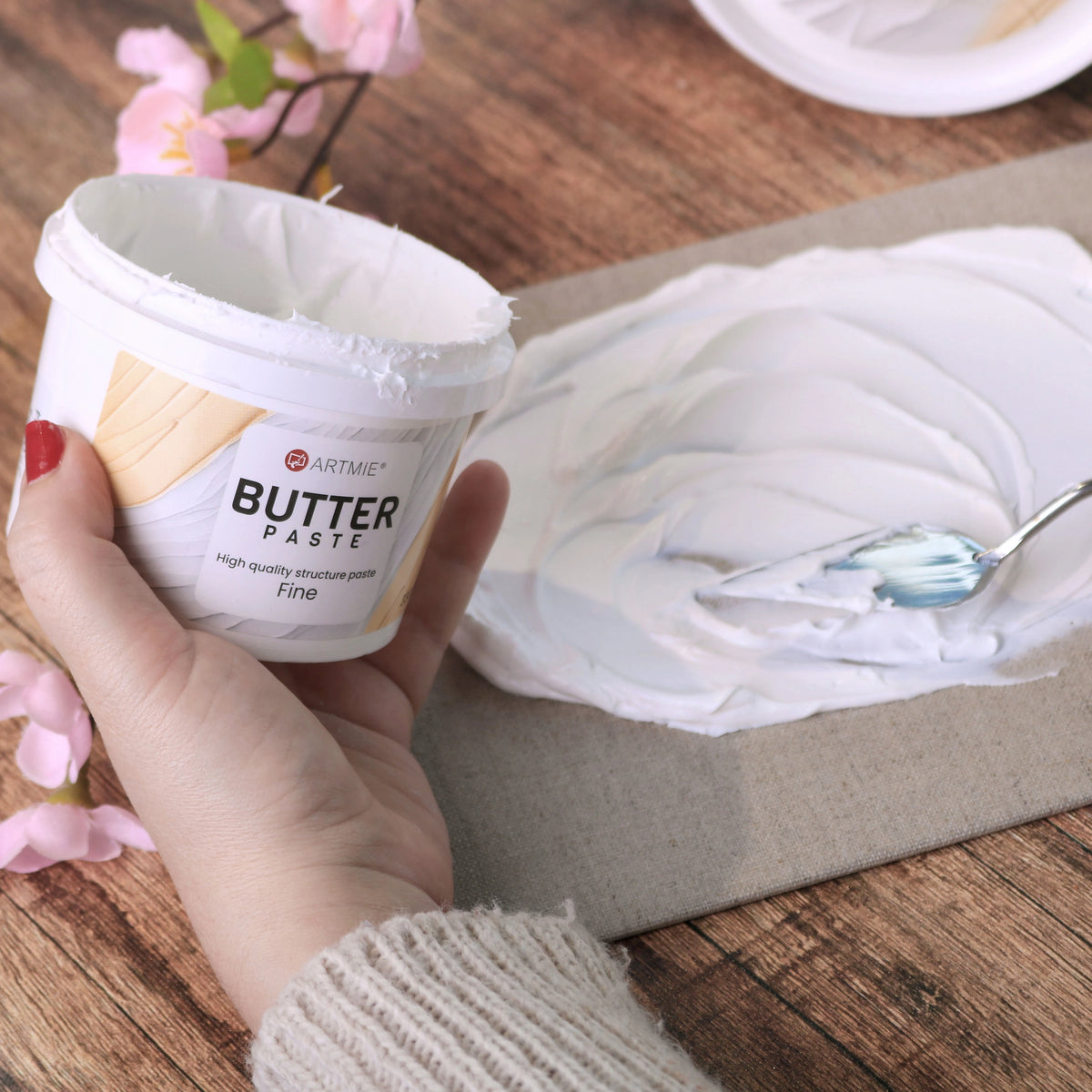 Geöffneter Becher und mit Malmesser auf Leinwand aufgetragene ARTMIE Butter Fine Paste