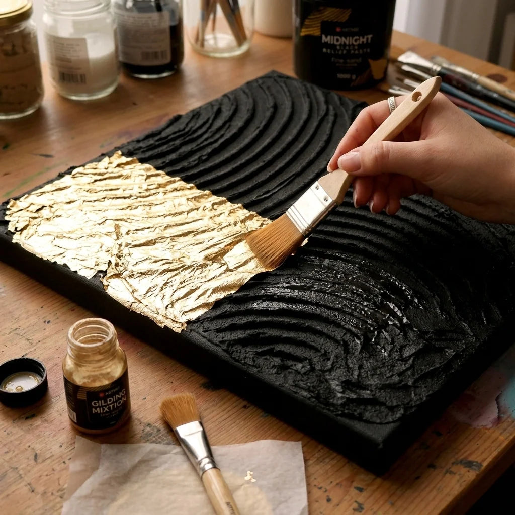 Auftragen von Schlagmetall auf ein trockenes Relief aus schwarzer Midnight 3D Strukturpaste
